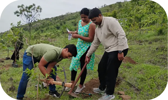 Participants planting saplings with guidance from team members
